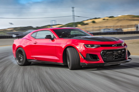 Red Camaro in motion representing the car-enthusiast spirit behind Sniff and Shift dog treats