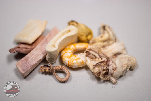A flat-lay lineup of Sniff and Shift freeze-dried treats on a garage floor