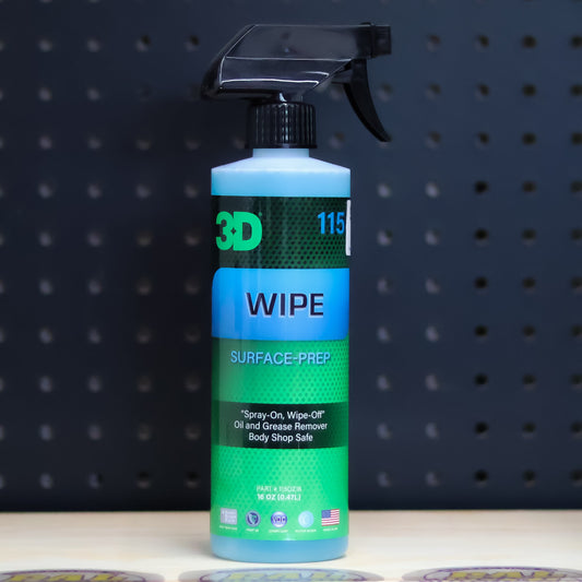 3D Wipe surface prep pint bottle, green and blue label with a black trigger sprayer, on a bench in front of a dark pegboard