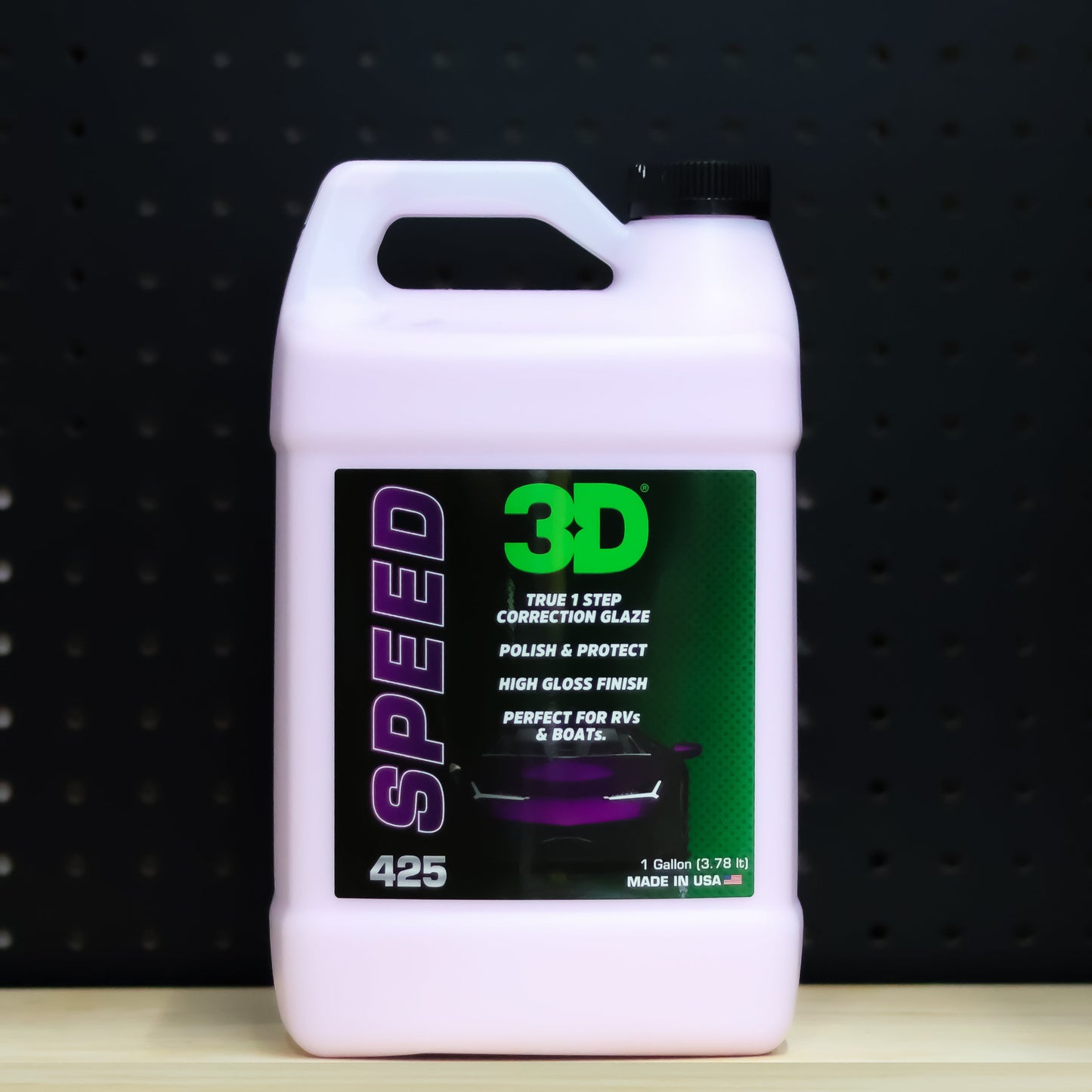3D SPEED 1 gallon jug, pink tinted bottle with a purple SPEED label and a carry handle, on a bench in front of a dark pegboard