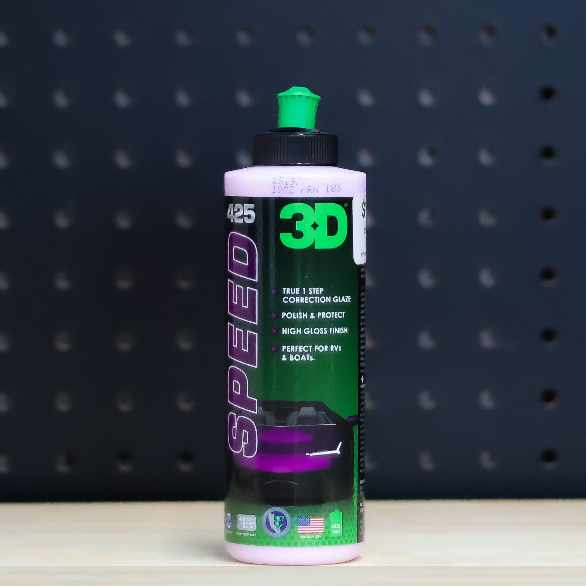3D SPEED 8 oz bottle, purple and black label with a green cap, standing on a bench in front of a dark pegboard wall