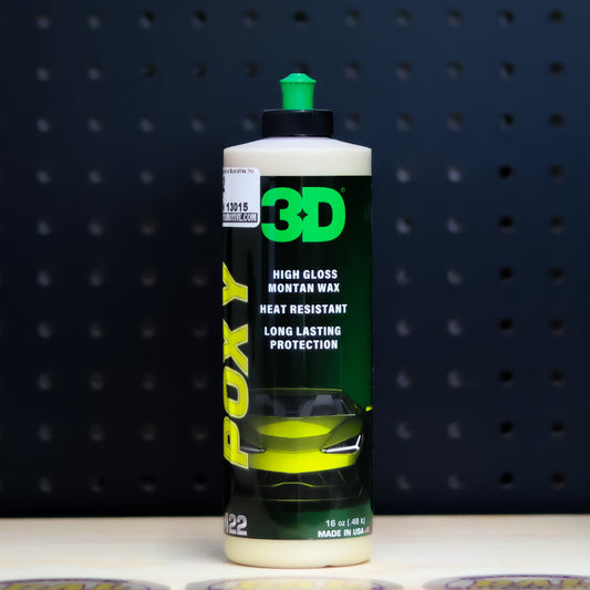 3D POXY pint bottle, black label with yellow POXY lettering and a green cap, against a dark pegboard wall