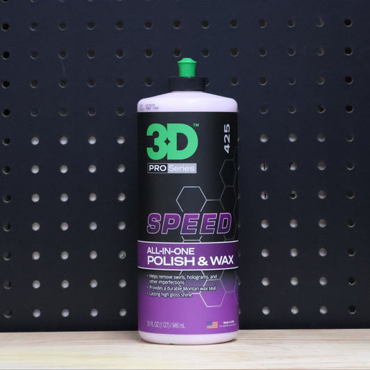 3D SPEED 32 oz bottle, purple and black all in one polish and wax label with a green cap, against a dark pegboard wall