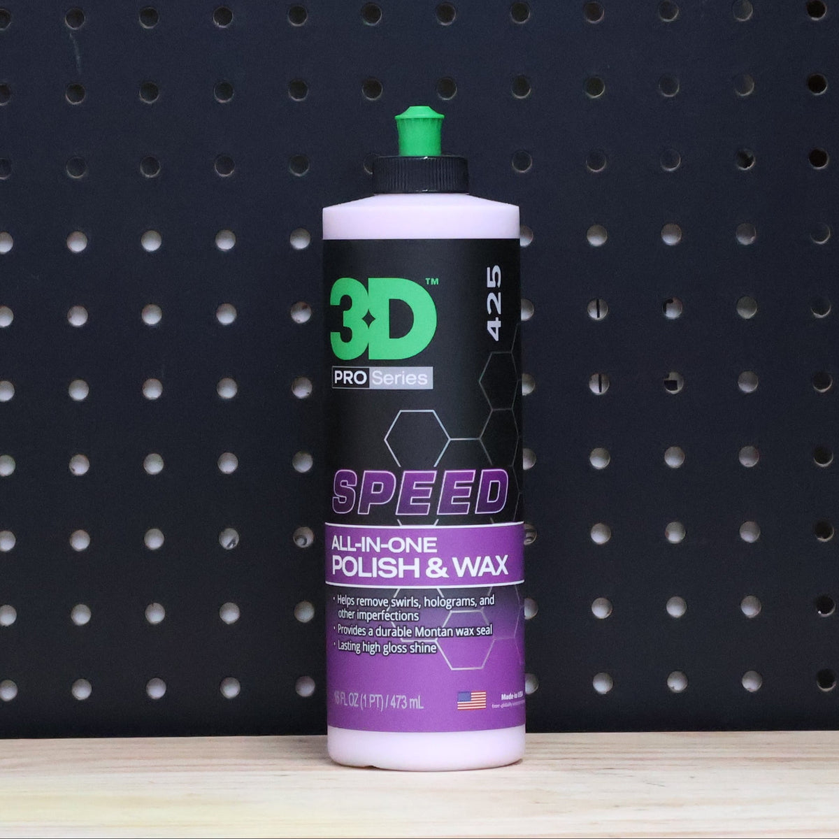 3D SPEED 16 oz bottle, purple and black all in one polish and wax label with a green cap, against a dark pegboard wall