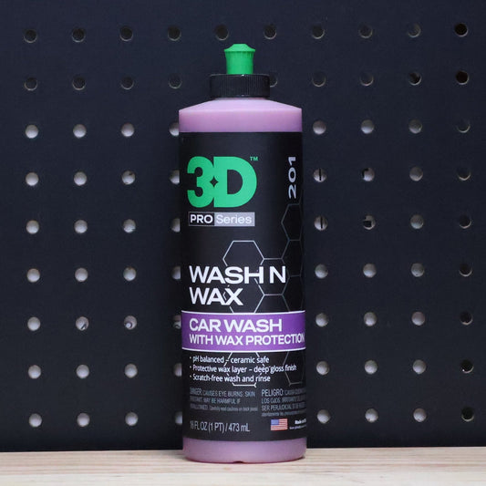 3D Wash N Wax 16 oz bottle, purple and black label with a green cap, standing against a dark pegboard wall