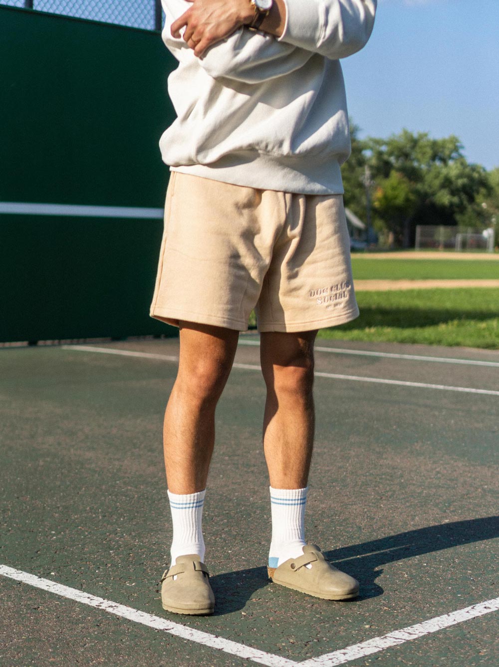 Adult wearing the Oat Embroidered Sweatshort with Dog Club Social embroidery, Good Thomas, sold through Sniff and Shift
