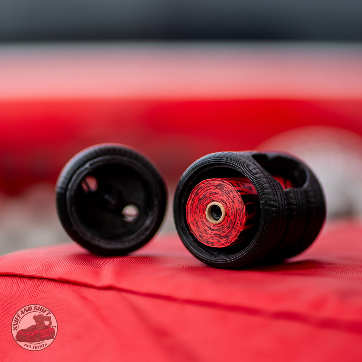 Two black tire covers with red and black striped inner lining, displayed on a red fabric surface. A circular 'Port & Shelf by Truck' logo is visible in the bottom-left corner.